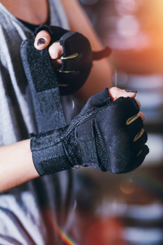 A woman puts on sports gloves for training