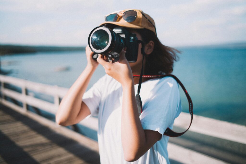 A woman with a camera in front of her face